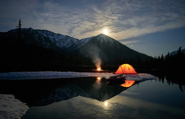 橙色帐篷在湖的海岸在晚上. 免版税图库照片