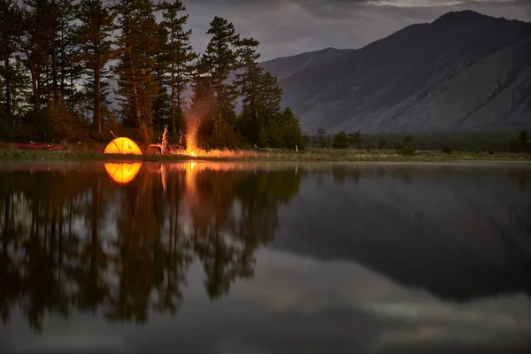橙色帐篷在湖的海岸在晚上. 图库图片