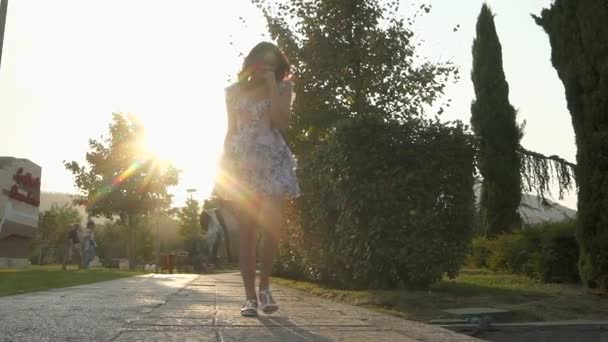 Slow motion of woman walking through city on pavement from behind — Stock Video