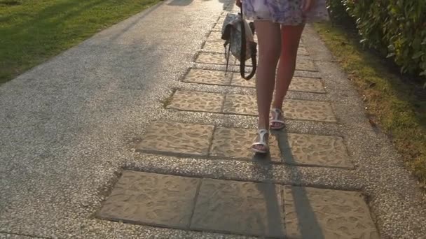 Slow motion detalj av kvinnans fötter gå genom staden på trottoaren bakifrån — Stockvideo