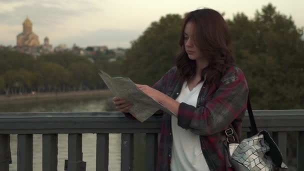 Красива молода жінка з туристичною картою виглядає збудженою на міській вулиці . — стокове відео
