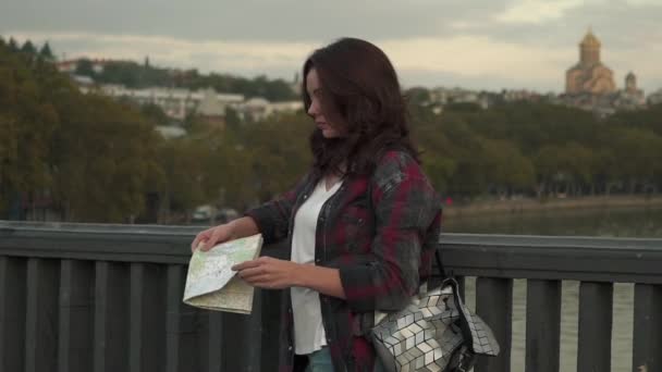 Hermosa mujer joven con mapa turístico que mira arjalá en la calle de la ciudad . — Vídeos de Stock