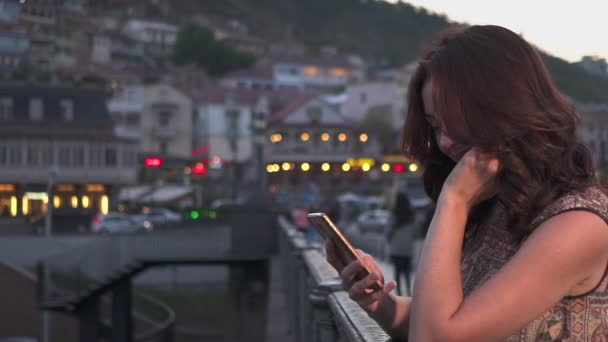 Mulher atraente usando telefone celular em ruas da cidade noturna. Movimento lento — Vídeo de Stock