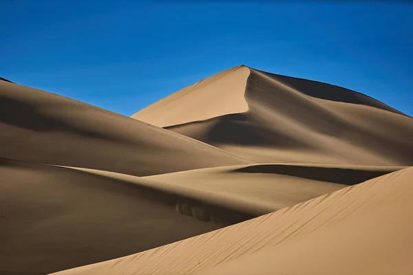 Sand dunes in the desert , warm dry sand under blue sky — Stock Photo, Image