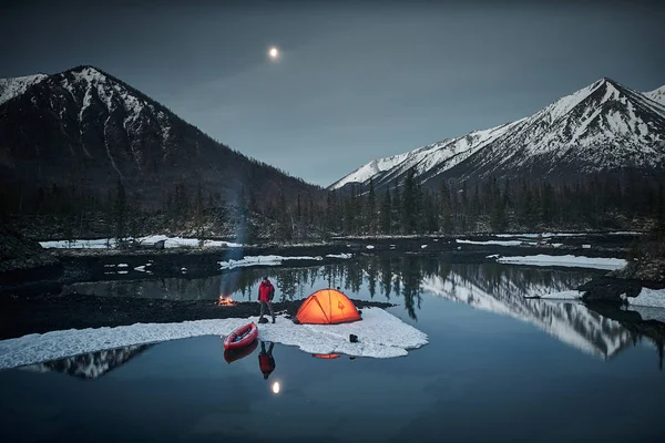 Vy över camp liv i en fjällterräng i vårens tid. Sjön med kanot — Stockfoto