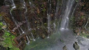 Bir nehir gösteren basamaklı şelale yaz yeşil yağmur ormanlarında Gürcistan'daki ağır çekimde yukarıda yükselen uçak