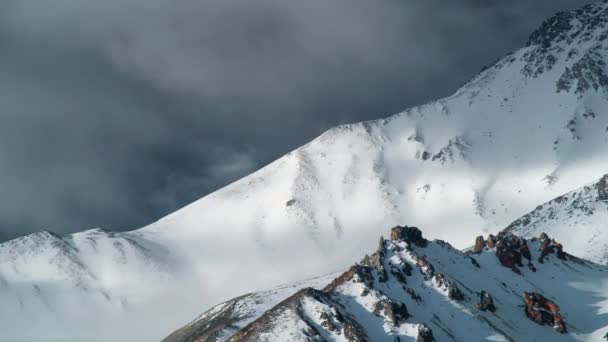 時間の経過、雲は冬で渦巻く雪で覆われた山. — ストック動画