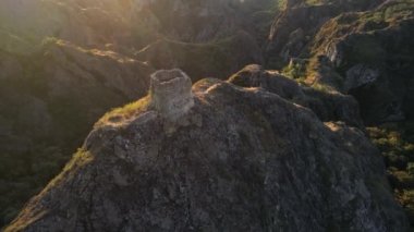 Gürcistan'daki antik küçük kale ile keskin kayalar üzerinde uçan. kale ile yapraklara yaktı. Kayaların arasına yeşil orman olduğunu