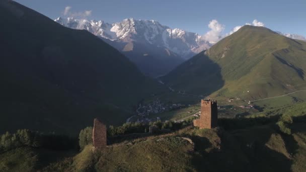 Съемки с воздуха древних Сванетских башен с деревней в долине — стоковое видео