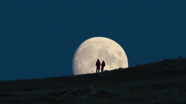 Silhueta de mulher e criança em pé contra enorme fundo da lua . — Vídeo de Stock