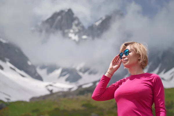 Närbild porträtt av vandring kvinna i rött på den vackra bergen bakgrund. — Stockfoto