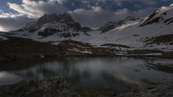 Lapso de tempo de nuvens, montanhas cobertas de neve e um lago — Vídeo de Stock