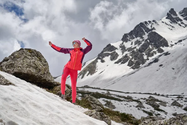 Porträt eines Touristen in Rot vor dem Hintergrund der wunderschönen Berge. — Stockfoto