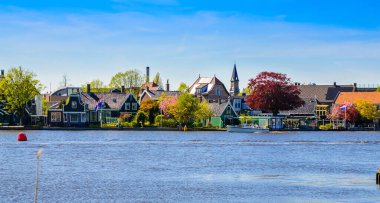 Geleneksel Hollanda yel değirmenleri ve Zaanse Schans, Hollanda, Avrupa 'daki kanal yakınlarındaki evler