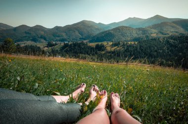 Kadın bacakları ve panoramik dağ manzarası. Dağlarda yaz