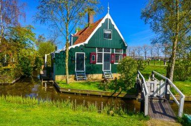 Geleneksel Hollanda yel değirmenleri ve Zaanse Schans, Hollanda, Avrupa 'daki kanal yakınlarındaki evler