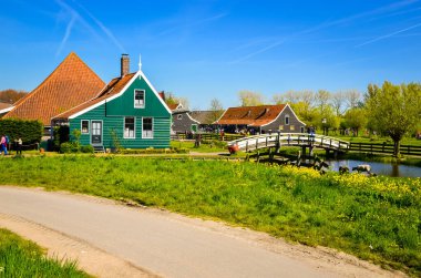 Geleneksel Hollanda yel değirmenleri ve Zaanse Schans, Hollanda, Avrupa 'daki kanal yakınlarındaki evler
