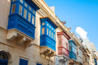 Sıcak sokak ve Sliema 'da geleneksel renkli ahşap balkonlar.,