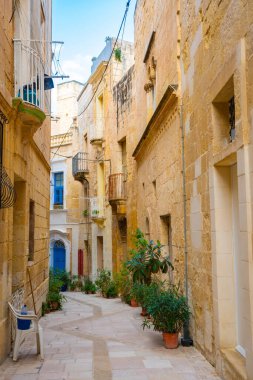 Birgu 'da rahat bir sokak ve geleneksel renkli ahşap balkonlar., 