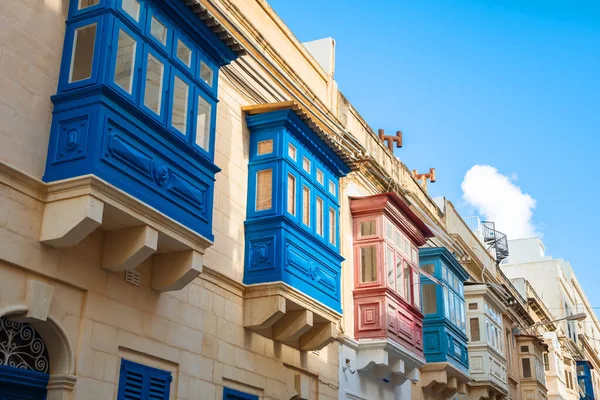Sıcak sokak ve Sliema 'da geleneksel renkli ahşap balkonlar.,