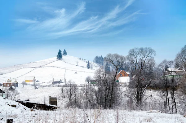 Karlı dağlarda köyü olan kış manzarası