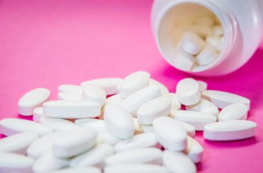 Pembe arka planda izole edilmiş eczane ve şişe. Tıbbi hap.