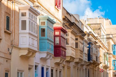 Sıcak sokak ve Sliema 'da geleneksel renkli ahşap balkonlar.,