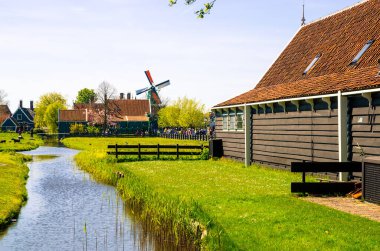 Geleneksel Hollanda yel değirmenleri ve Zaanse Schans, Hollanda, Avrupa 'daki kanal yakınlarındaki evler