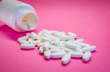 Pembe arka planda izole edilmiş eczane ve şişe. Tıbbi hap.