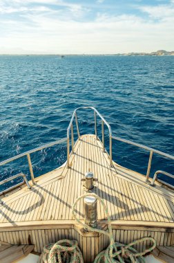 Manzaralı yattan deniz dalgalarına, ada yaraları ve ufuk manzarası. Kızıl Deniz 'in ultamarin dalgaları. Yat, Junehorizon 'daki deniz dalgaları ve ada manzaralı. pruvada bit.