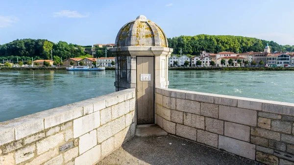 Şehir manzarası, nehir, sokaklar ve bulutlu güneşli bir günde bazı binalar.
