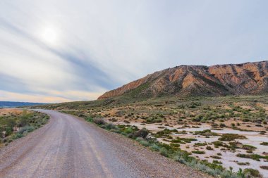 Güneşli bir günde yarı çöl manzarası. Bir de yol var.