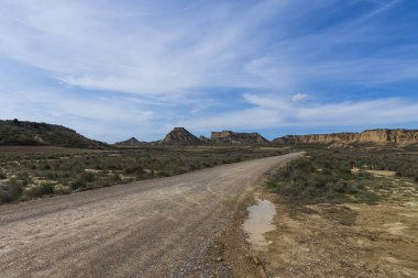 Güneşli bir günde yarı çöl manzarası. Bir de yol var.