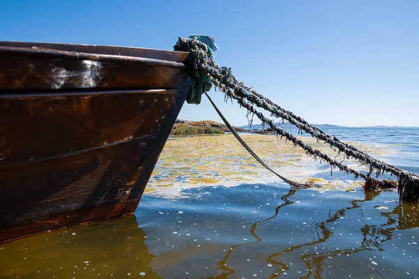 Sudaki tekneyi ve arka plandaki sahili bir yaz günü görmek