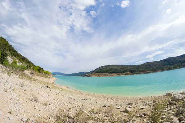 Göl manzarası, dağlar ve gökyüzü güneş ve bulutlarla