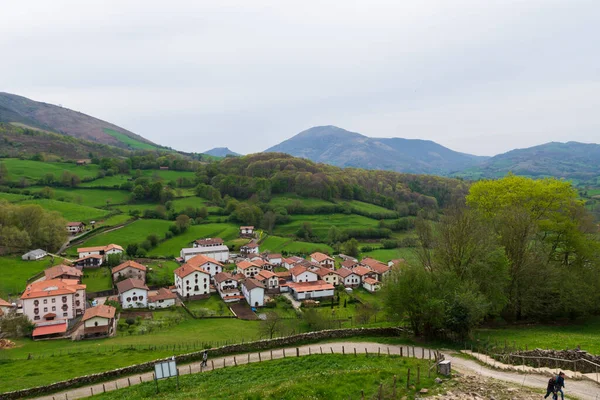 Dağların panoramik manzarası, bölgenin tipik binaları ve doğal bitki örtüsü.