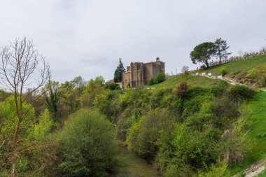 Dağ yamacındaki bitki örtüsünün ortasındaki kilisenin manzarası.