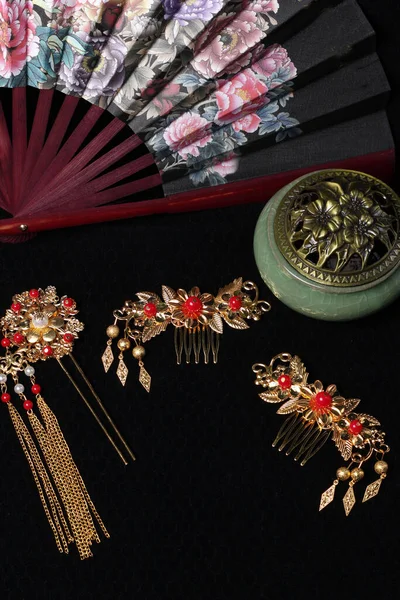 Chinese traditional wedding women\'s jewelry hairpins. fan and incense burner. still-life
