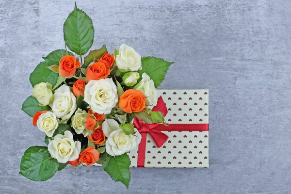 Gri desenli arka planda çiçekler ve hediye kutusu — Stok fotoğraf