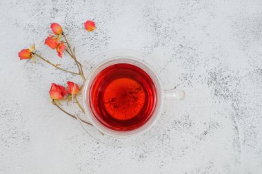 Bir bardak çay ve güllerin üst görüntüsü.