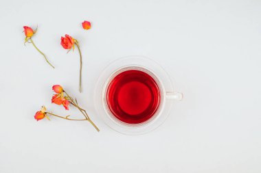 Beyaz arka planda bir fincan çay ve güller