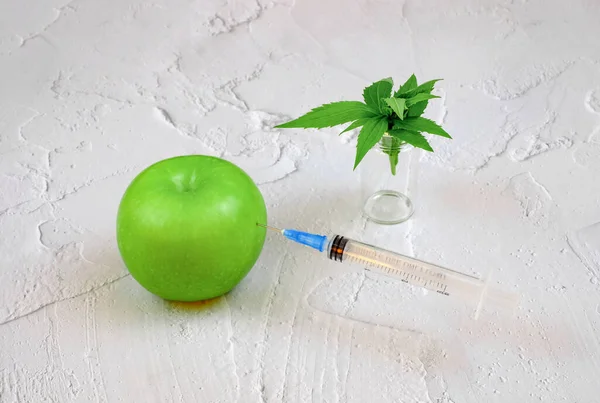 Medicinsk spruta har fastnat i ett grönt äpple och gröna blad — Stockfoto