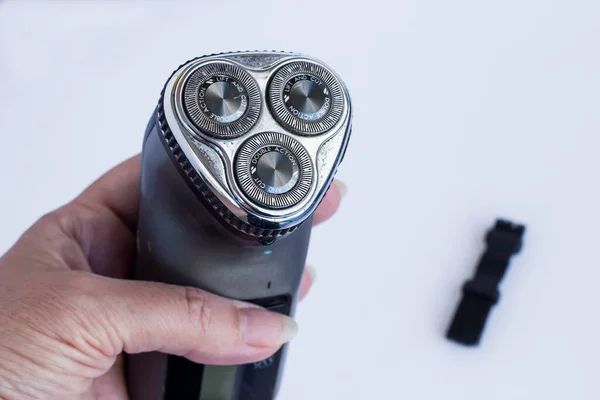 A Black Electric Shaver in hand holding on white background with copy space.