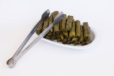 Sarmalar, beyaz tabakta ıslak üzüm yaprakları yuvarlanması, geleneksel Türk Gıda Hazırlığı, yukarıdan bakıldığında.