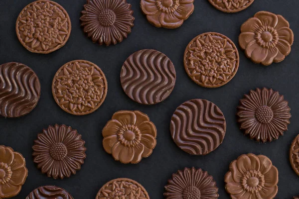 Sütlü ve sert yuvarlak çikolatalı Madlen, siyah arka planda, top çikolatalı ve tahıllı..