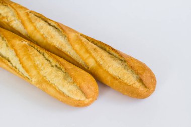 Beyaz yüzeyde taze baget ekmeği. Bıçakla, üst tarafta..