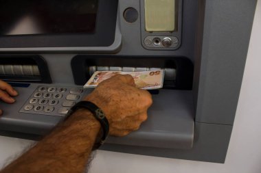 Türk parasıyla bankamatik kullanan yetişkin adamın eli