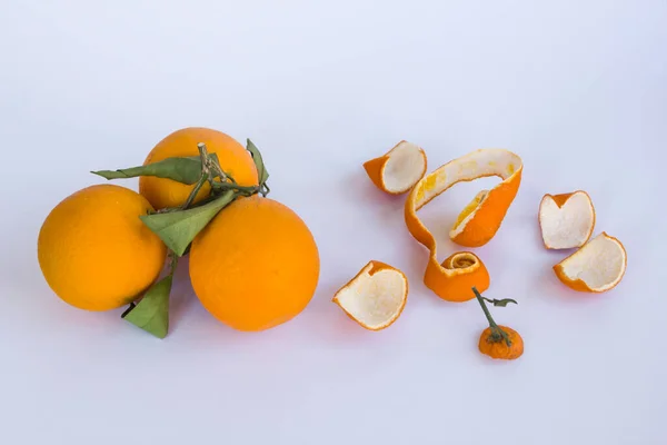 Ripe and fresh orange on the white with copy space and peeled orange peels