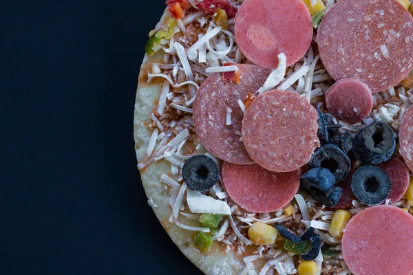 Siyah üzerine pişmemiş, fotokopi alanı olan dondurulmamış pizza..