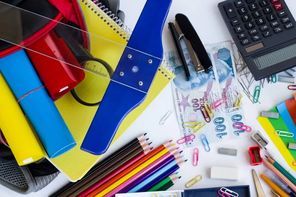 Beyaz arka planda Türk parasıyla renkli okul malzemeleri. Okul alışverişi konsepti..